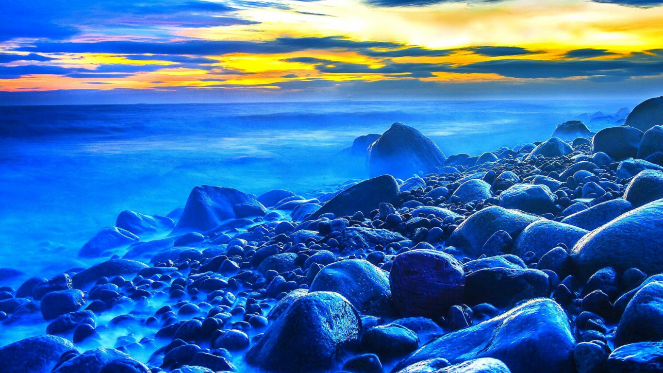 Black and Gray Rocks on Sea Shore During Sunset. Wallpaper in 1366x768 Resolution