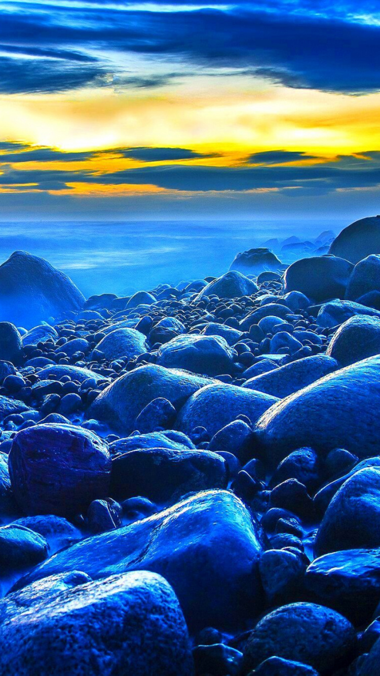 Schwarze Und Graue Felsen am Meer Bei Sonnenuntergang. Wallpaper in 750x1334 Resolution