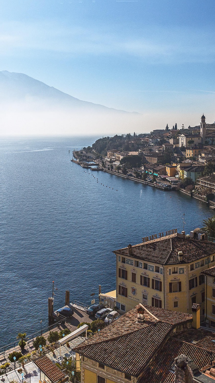 Edificio de Hormigón Marrón Cerca Del Cuerpo de Agua Durante el Día. Wallpaper in 720x1280 Resolution