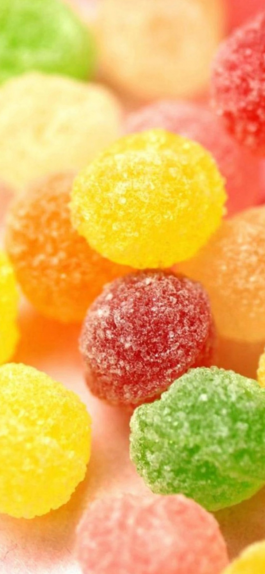 Yellow Pink Green and Orange Candies. Wallpaper in 1125x2436 Resolution