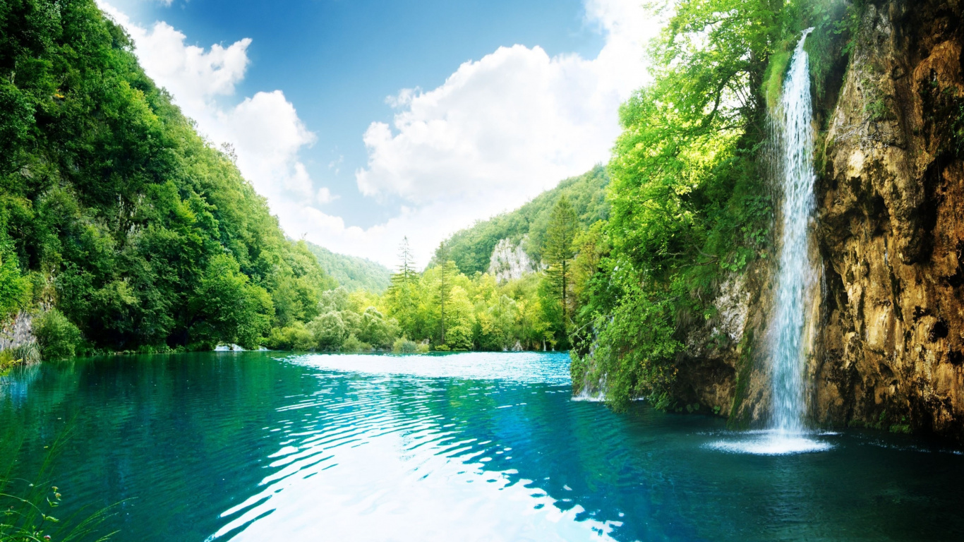 Green Trees Beside River Under Blue Sky During Daytime. Wallpaper in 1366x768 Resolution