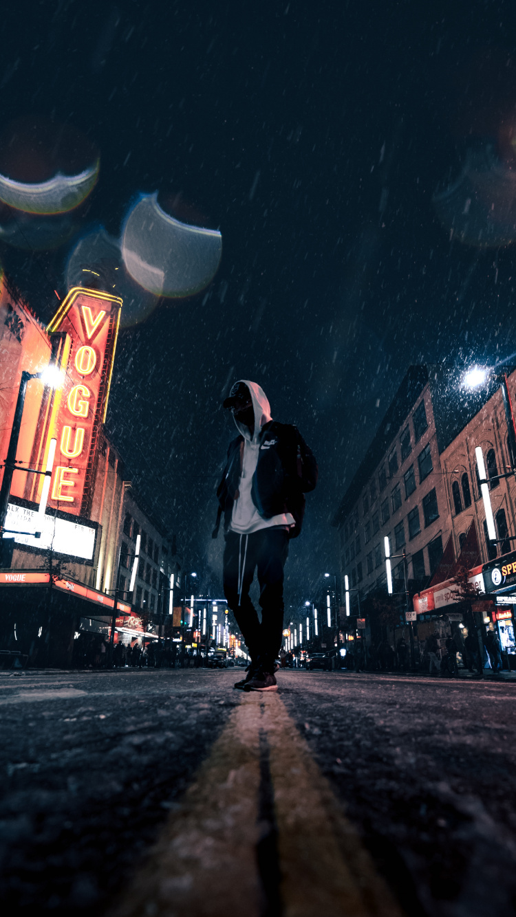Man in White Shirt and Black Pants Walking on Street During Night Time. Wallpaper in 750x1334 Resolution