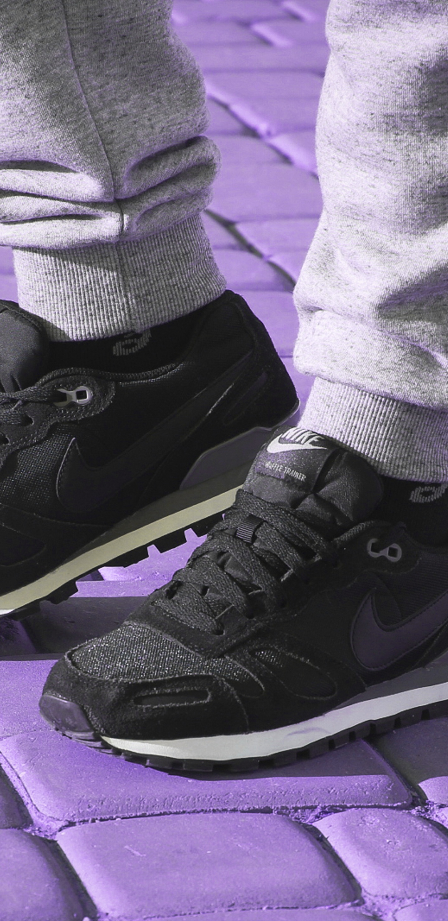 Person in Gray Pants Wearing Black Nike Sneakers. Wallpaper in 1440x2960 Resolution