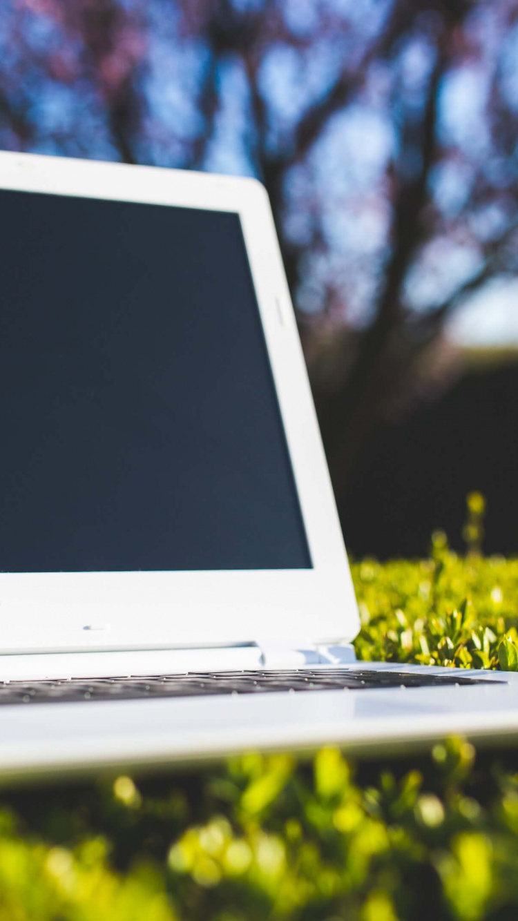 Weißer Acer-Laptop-Computer Auf Gelbem Blumenfeld. Wallpaper in 750x1334 Resolution