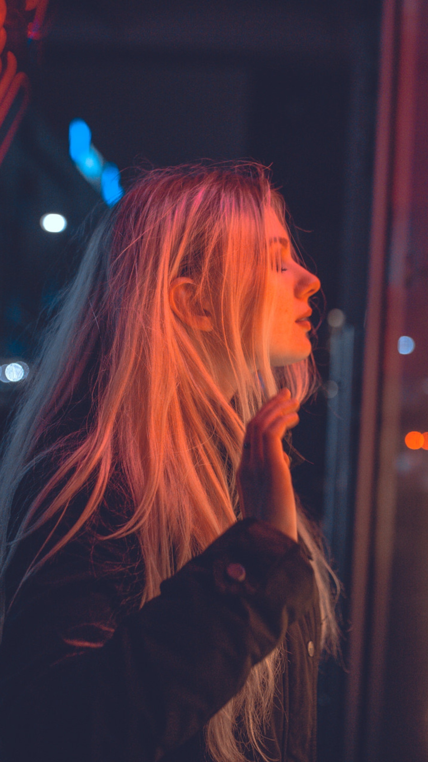 Frau im Schwarzen Langarmhemd, Die in Der Nähe Von Roten Und Gelben Neonlichtschildern Steht. Wallpaper in 1440x2560 Resolution