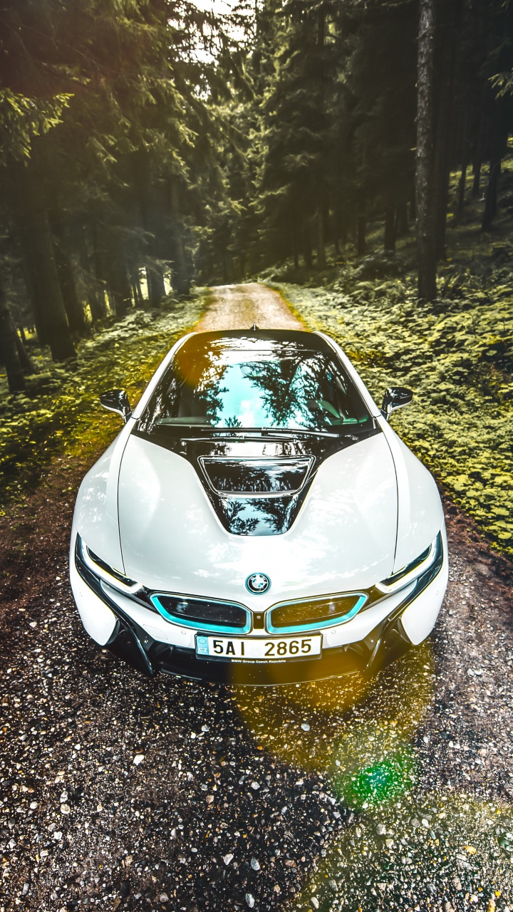 Blaues Auto Auf Der Straße Zwischen Bäumen Tagsüber. Wallpaper in 720x1280 Resolution