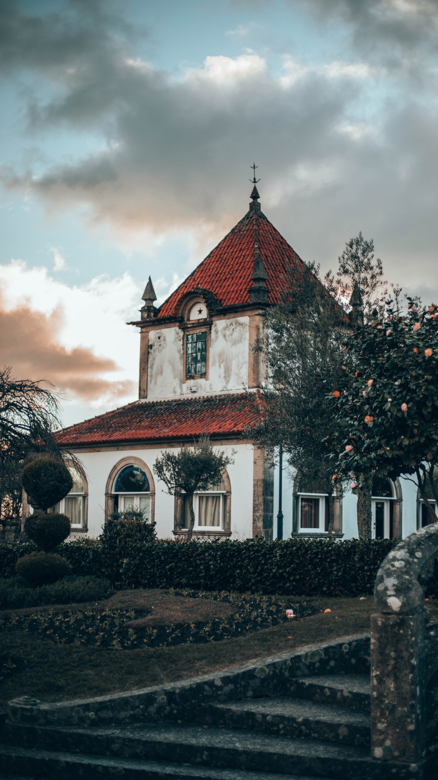 Rotes Und Weißes Betongebäude in Der Nähe Von Grünen Bäumen Unter Weißen Wolken Tagsüber. Wallpaper in 1440x2560 Resolution