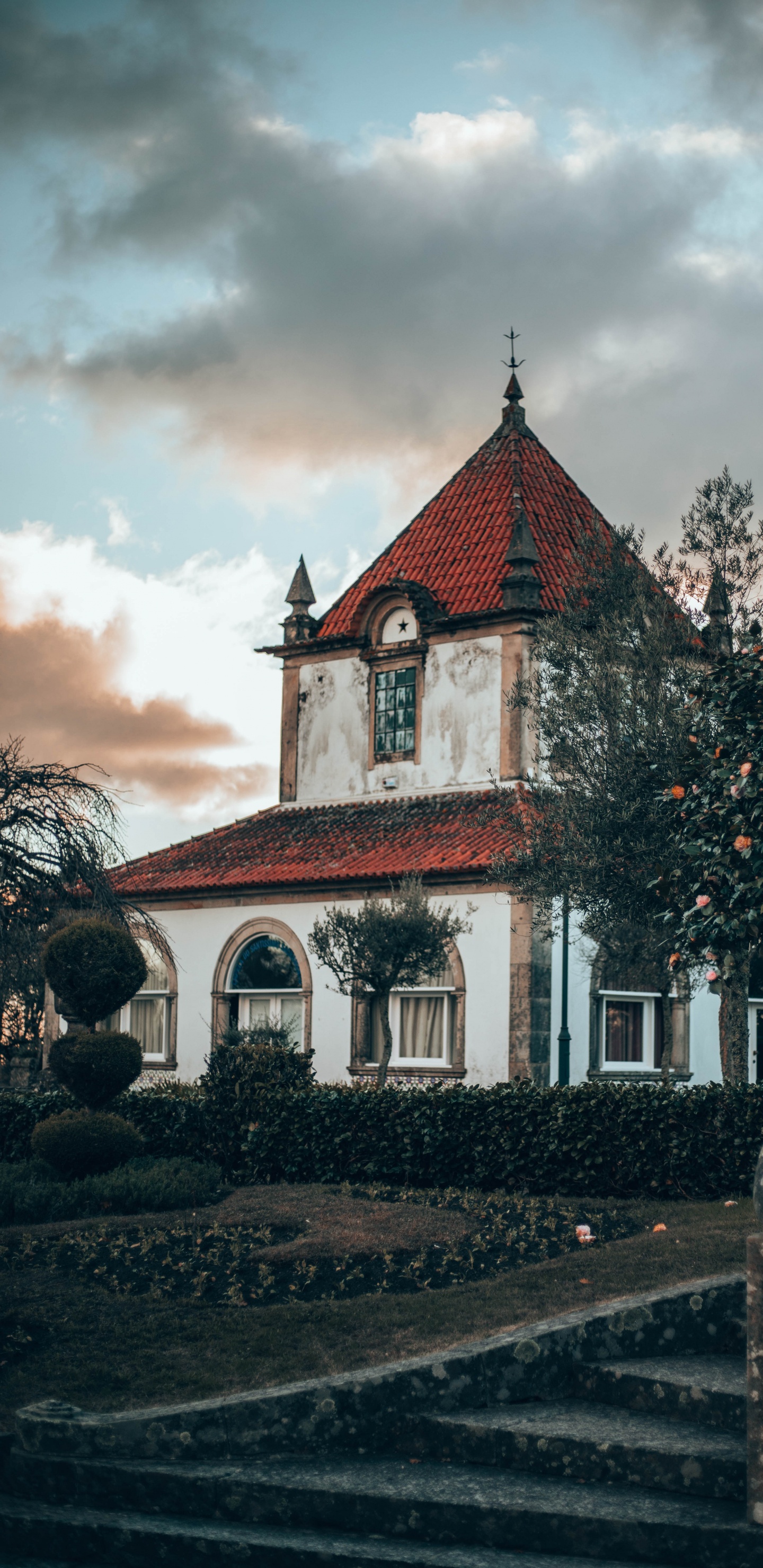 Rotes Und Weißes Betongebäude in Der Nähe Von Grünen Bäumen Unter Weißen Wolken Tagsüber. Wallpaper in 1440x2960 Resolution