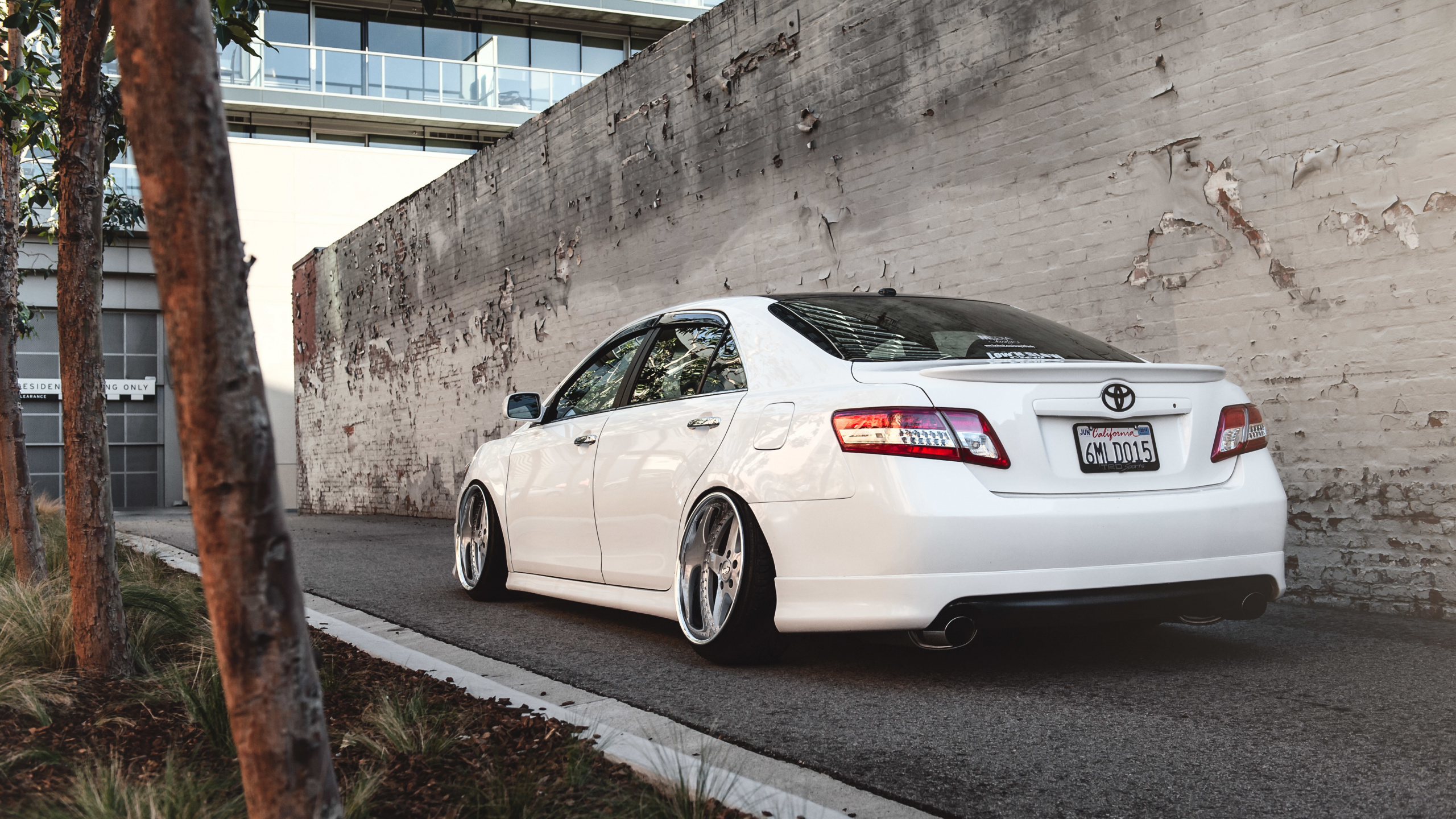 Weißer Porsche 911 Geparkt Neben Grauer Betonwand. Wallpaper in 2560x1440 Resolution