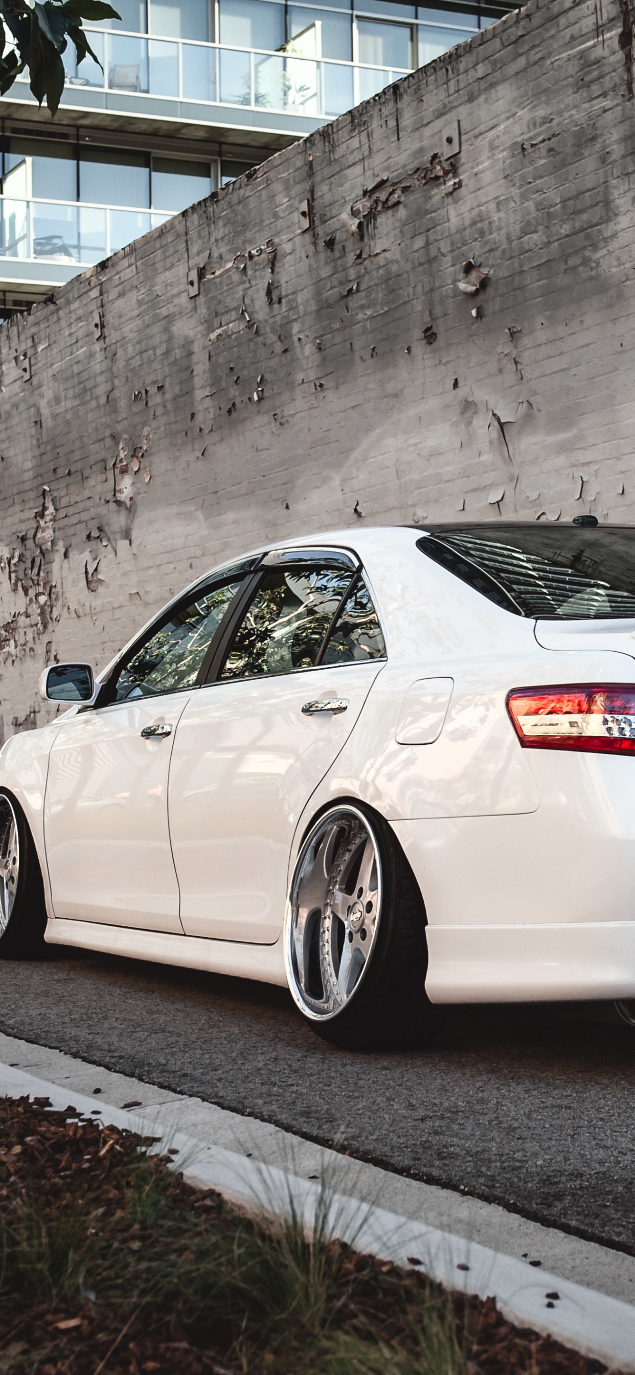 Porsche 911 Blanche Garée à Côté D'un Mur de Béton Gris. Wallpaper in 1242x2688 Resolution