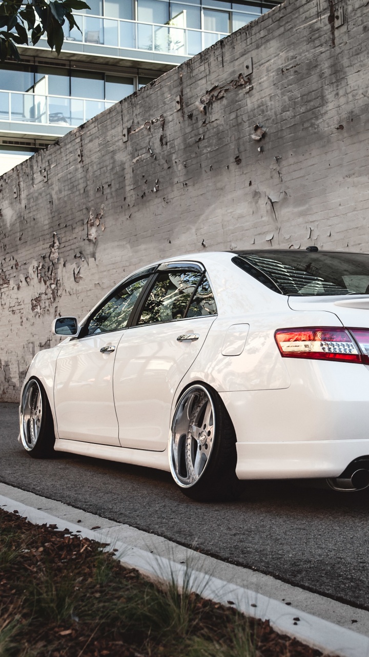Porsche 911 Blanco Estacionado Junto a un Muro de Hormigón Gris. Wallpaper in 720x1280 Resolution