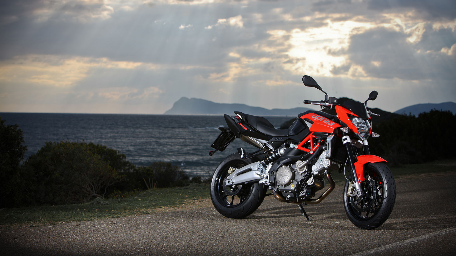Black and Orange Sports Bike Parked on Gray Concrete Road Near Body of Water During Daytime. Wallpaper in 1920x1080 Resolution