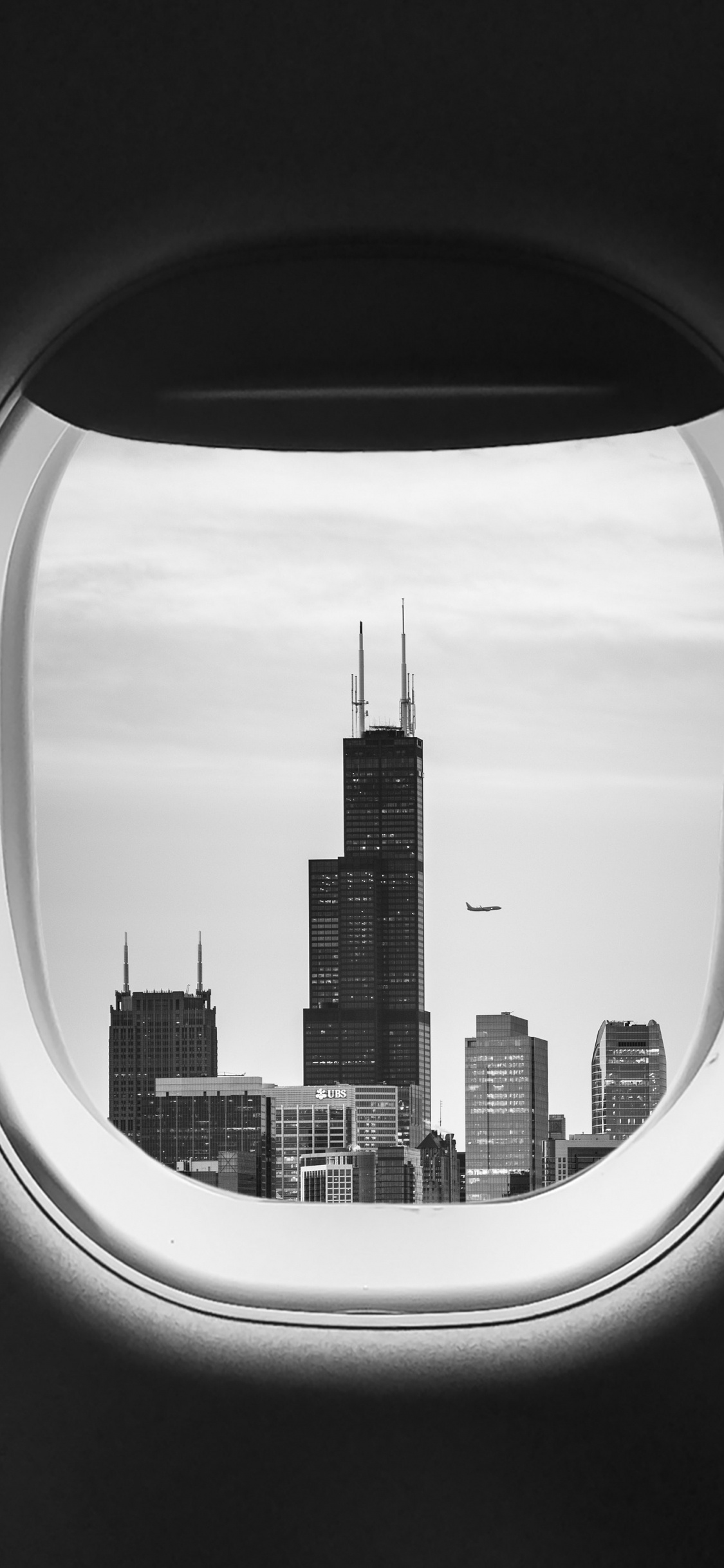 Vista de la Ventana Del Avión de Los Edificios de la Ciudad Durante el Día.. Wallpaper in 1125x2436 Resolution