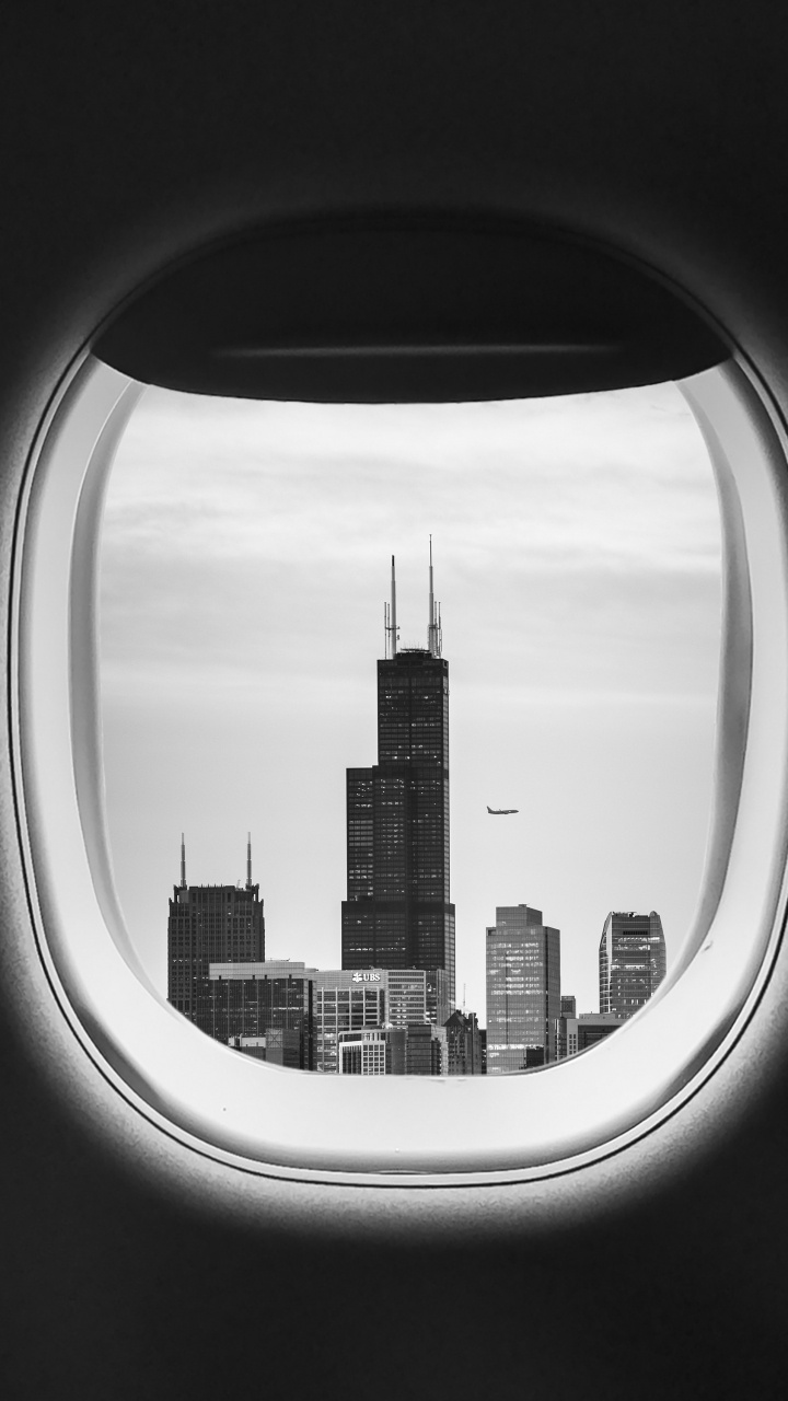 Flugzeugfensteransicht Von Stadtgebäuden Während Des Tages. Wallpaper in 720x1280 Resolution
