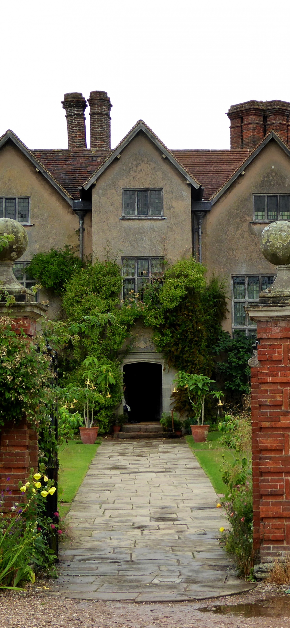 Casa de Ladrillo Marrón Con Plantas Verdes. Wallpaper in 1125x2436 Resolution