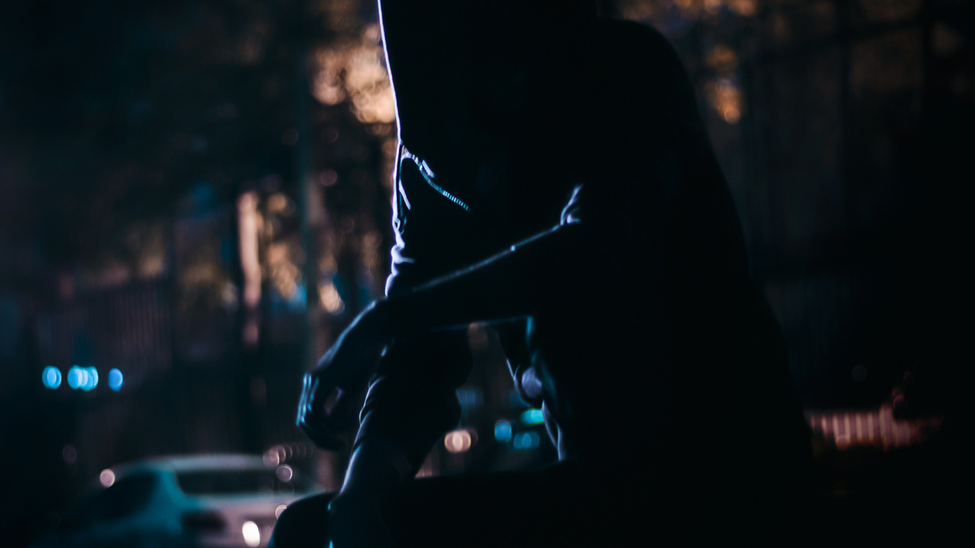 Silhouette Einer Person, Die Nachts Auf Der Straße Sitzt. Wallpaper in 1366x768 Resolution