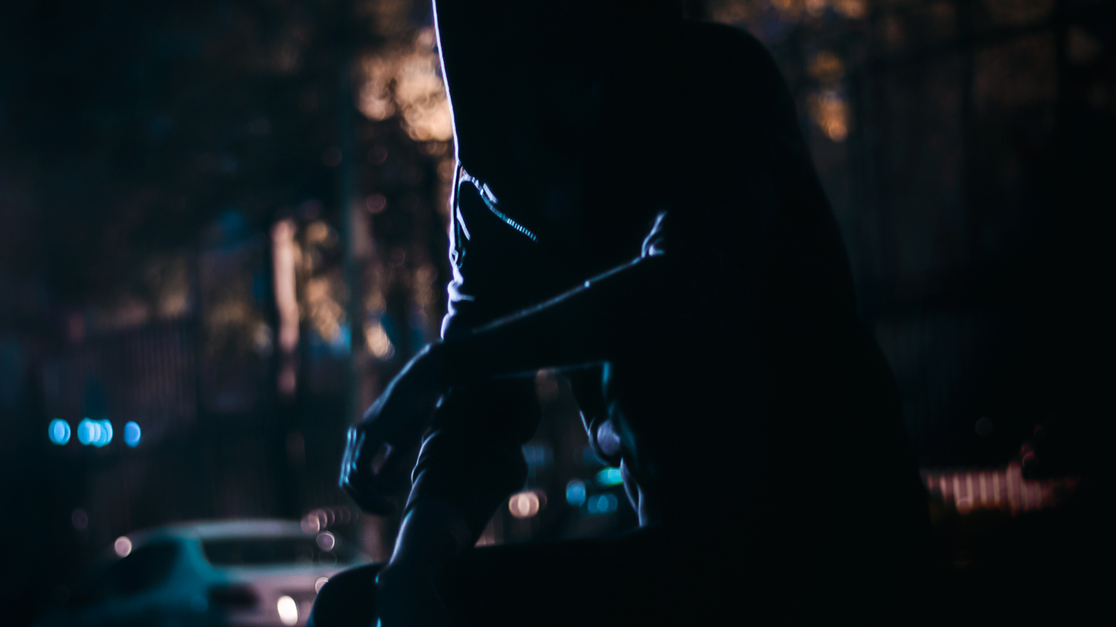 Silhouette Einer Person, Die Nachts Auf Der Straße Sitzt. Wallpaper in 3840x2160 Resolution