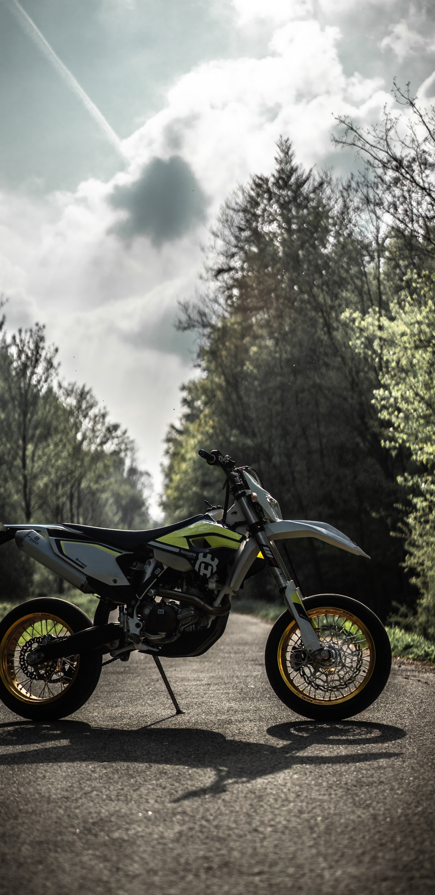 Black Motorcycle Parked on Dirt Road Near Green Trees During Daytime. Wallpaper in 1440x2960 Resolution
