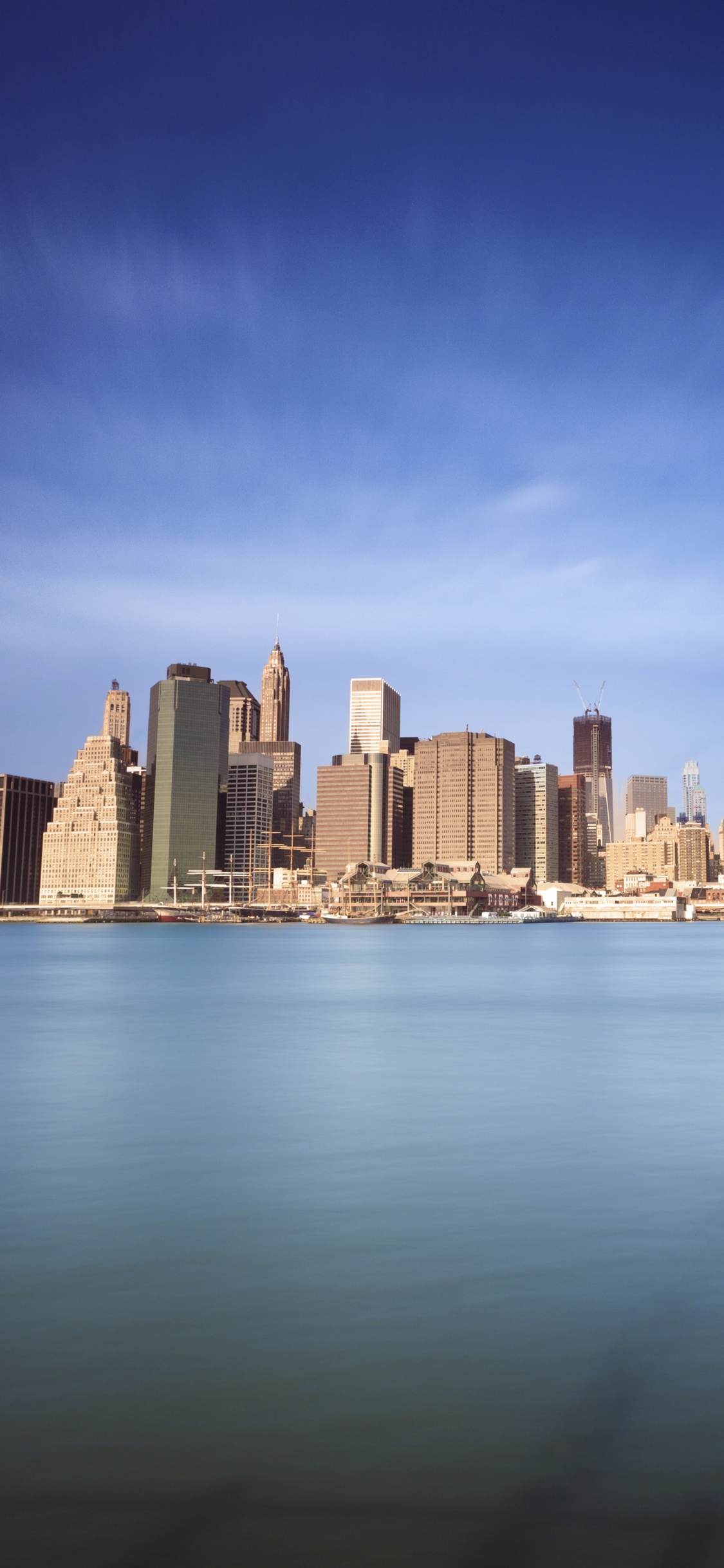 City Skyline Across Body of Water During Daytime. Wallpaper in 1125x2436 Resolution