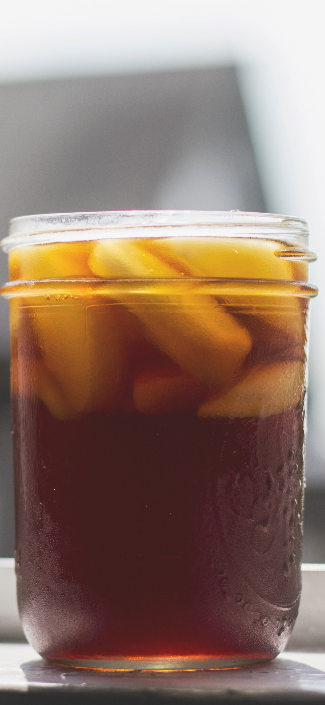 Clear Glass Jar With Brown Liquid Inside. Wallpaper in 1125x2436 Resolution