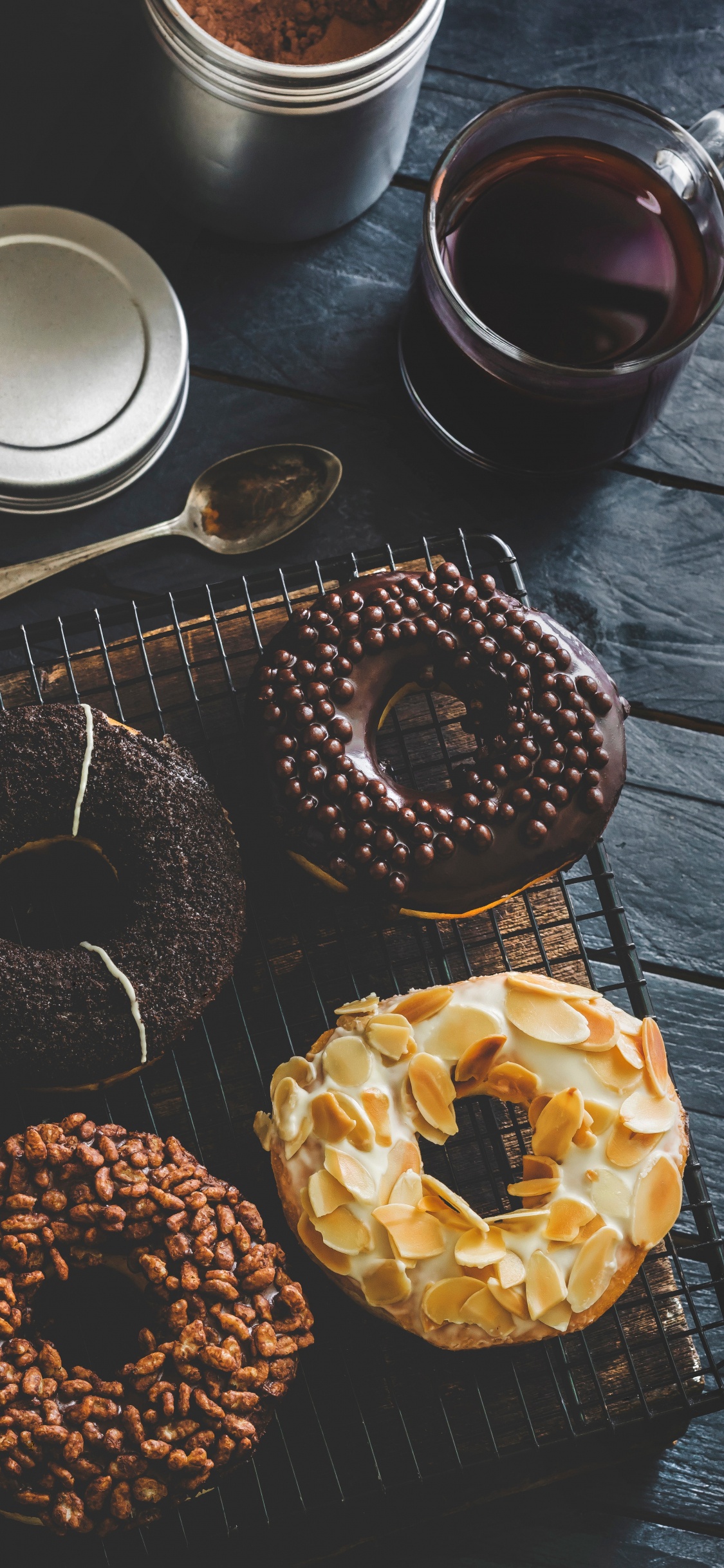 Donuts Auf Braunem Holztisch. Wallpaper in 1125x2436 Resolution