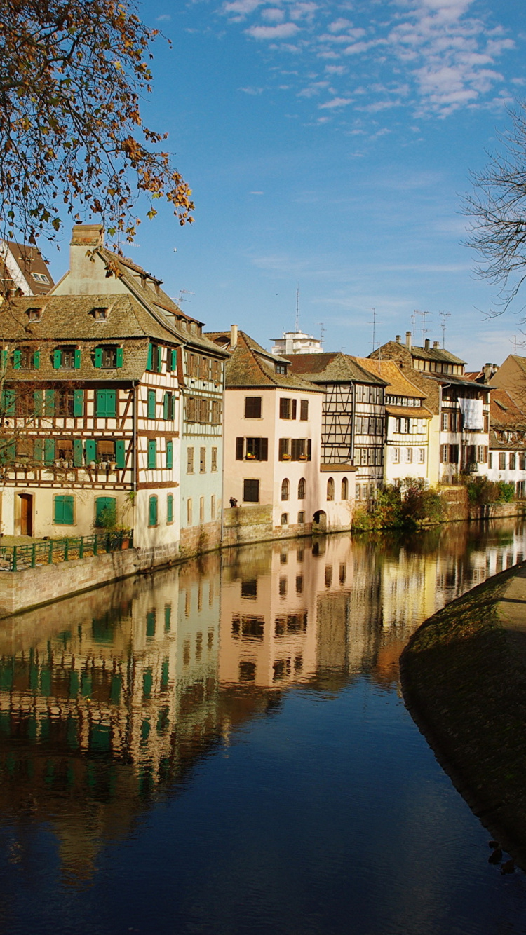 Weißes Und Braunes Betongebäude in Der Nähe Von Gewässern Unter Blauem Himmel Tagsüber. Wallpaper in 750x1334 Resolution