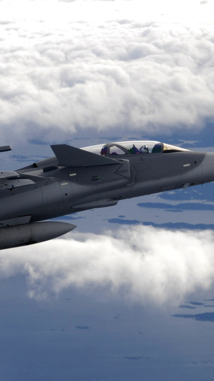 Grauer Kampfjet, Der Tagsüber Über Weiße Wolken Fliegt. Wallpaper in 750x1334 Resolution