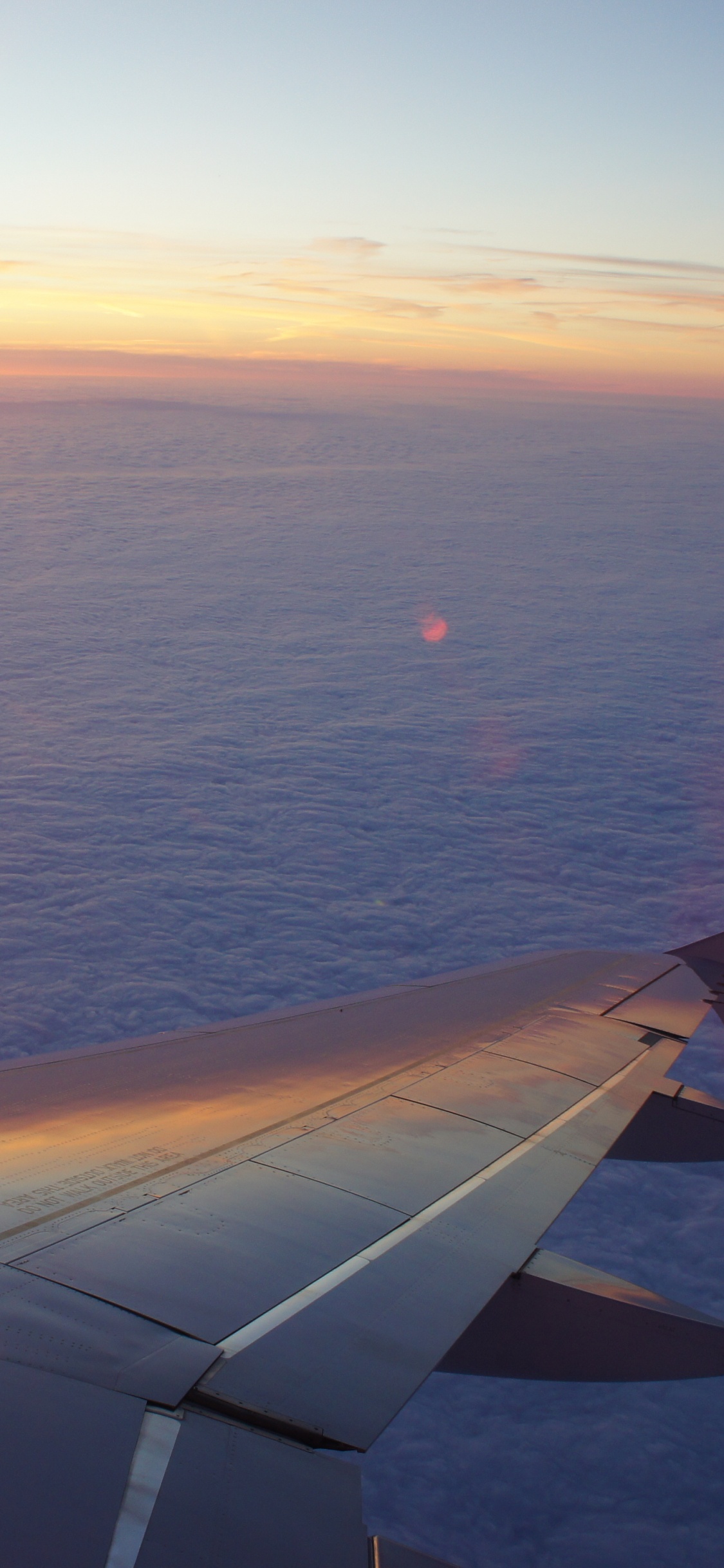 Flugzeugflügel Über Dem Meer Bei Sonnenuntergang. Wallpaper in 1125x2436 Resolution