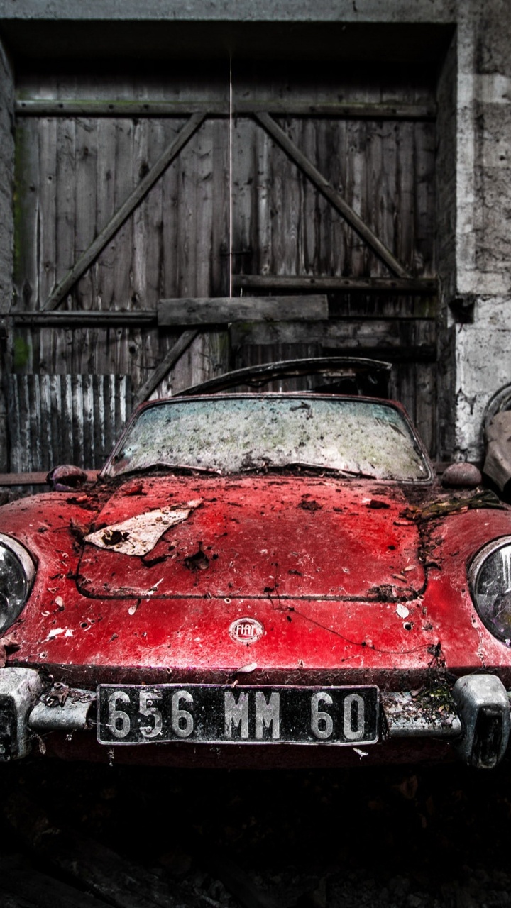 Red Car Parked Beside Building. Wallpaper in 720x1280 Resolution