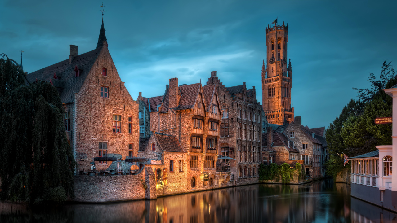 Bâtiment en Béton Brun Près D'un Plan D'eau Sous un Ciel Bleu Pendant la Journée. Wallpaper in 1280x720 Resolution