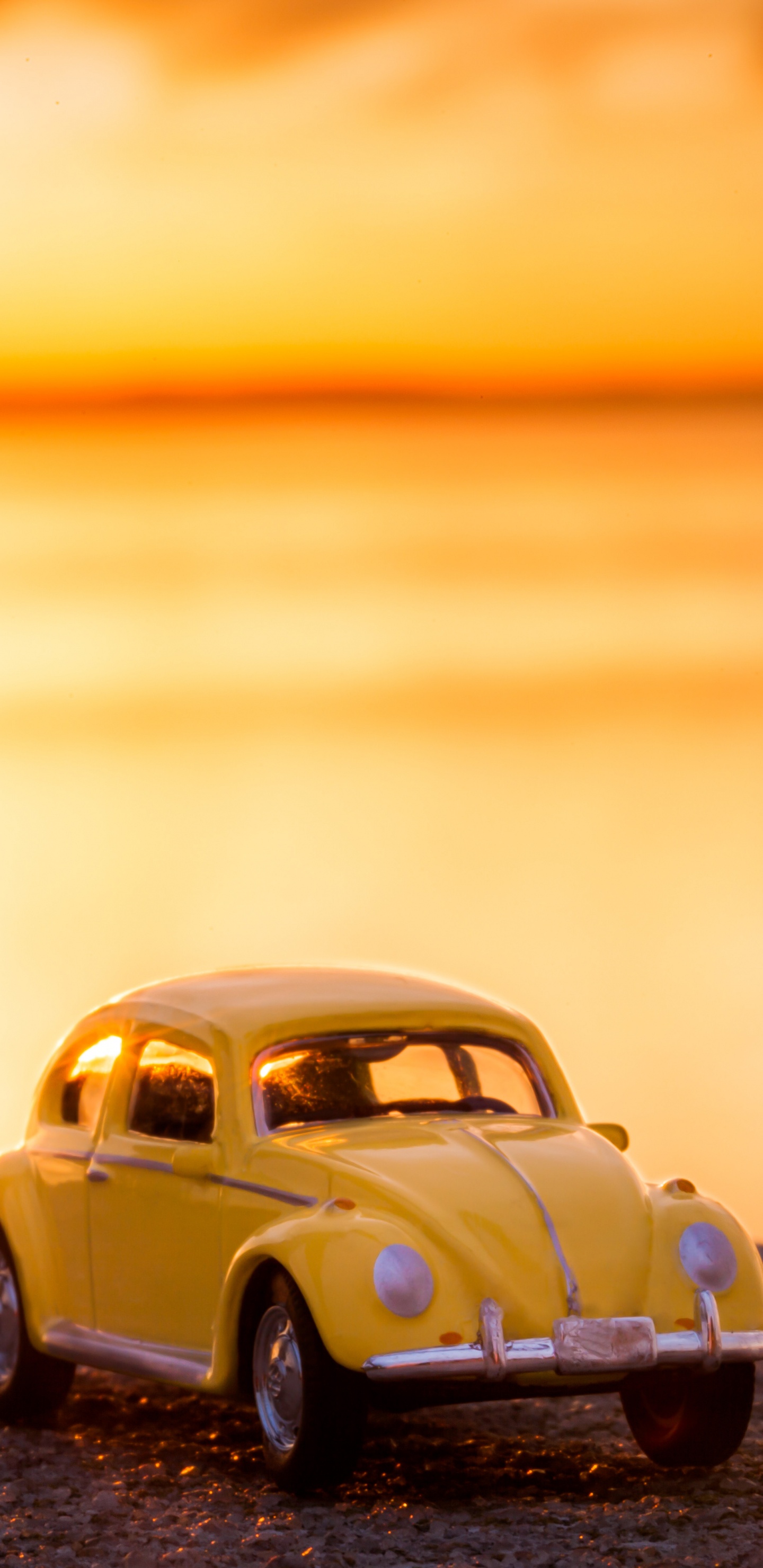 Volkswagen Beetle Jaune Sur le Rivage Pendant le Coucher du Soleil. Wallpaper in 1440x2960 Resolution
