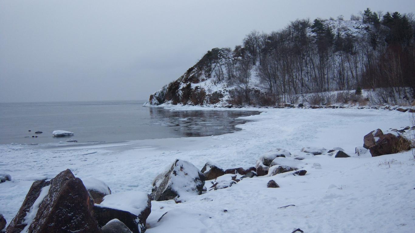 Snow Covered Rocks by The Sea During Daytime. Wallpaper in 1366x768 Resolution