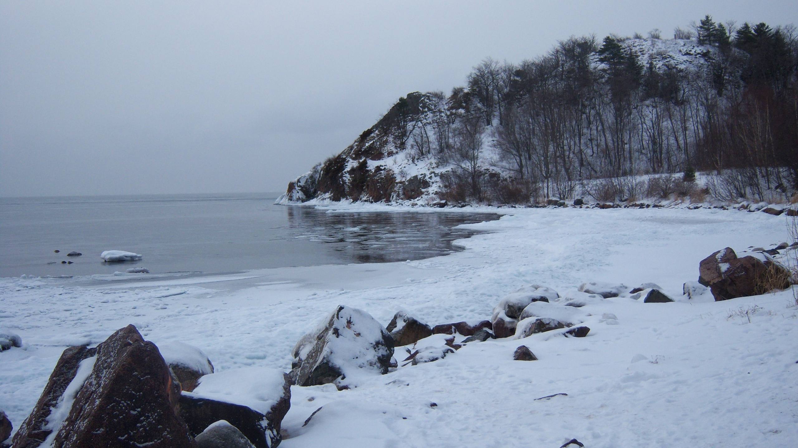 Snow Covered Rocks by The Sea During Daytime. Wallpaper in 2560x1440 Resolution