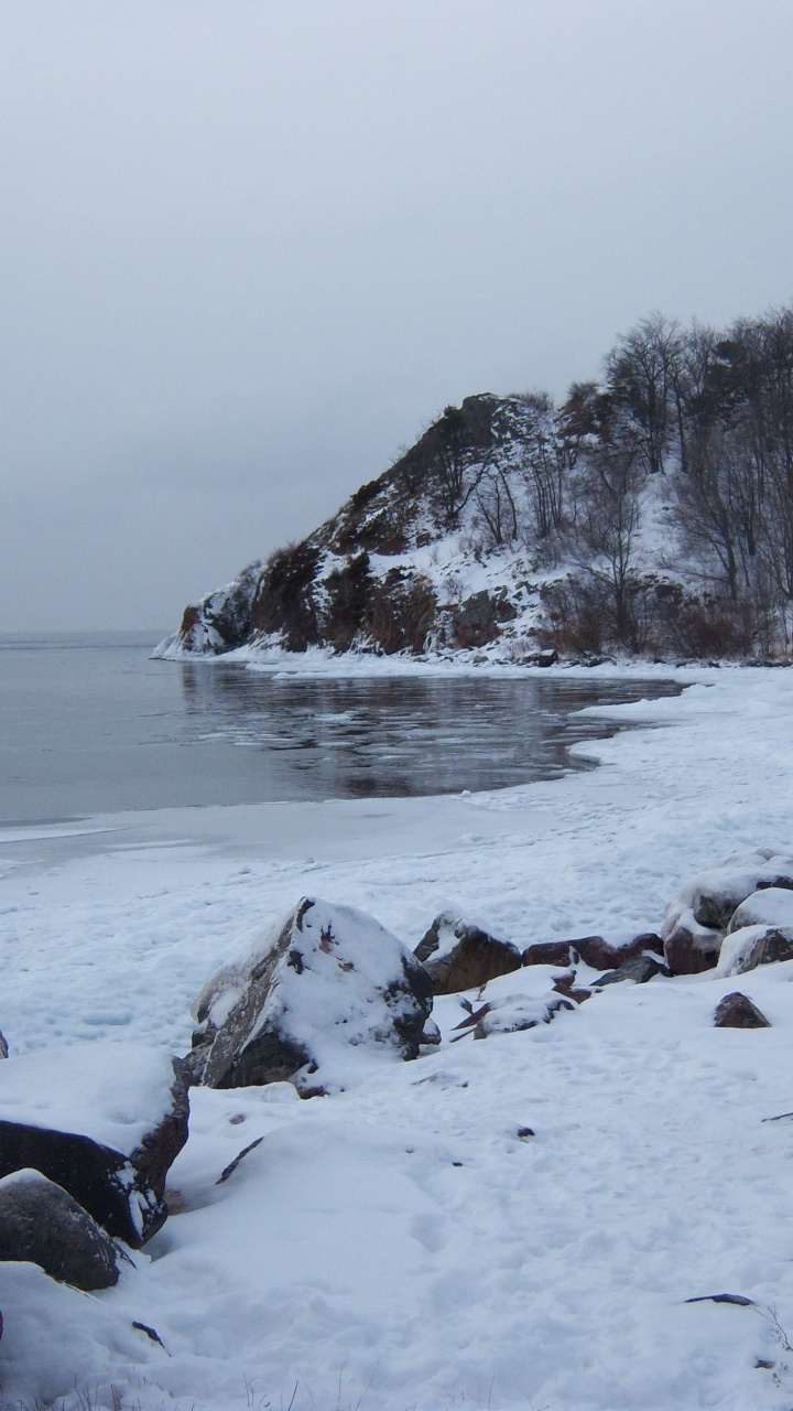 Snow Covered Rocks by The Sea During Daytime. Wallpaper in 720x1280 Resolution