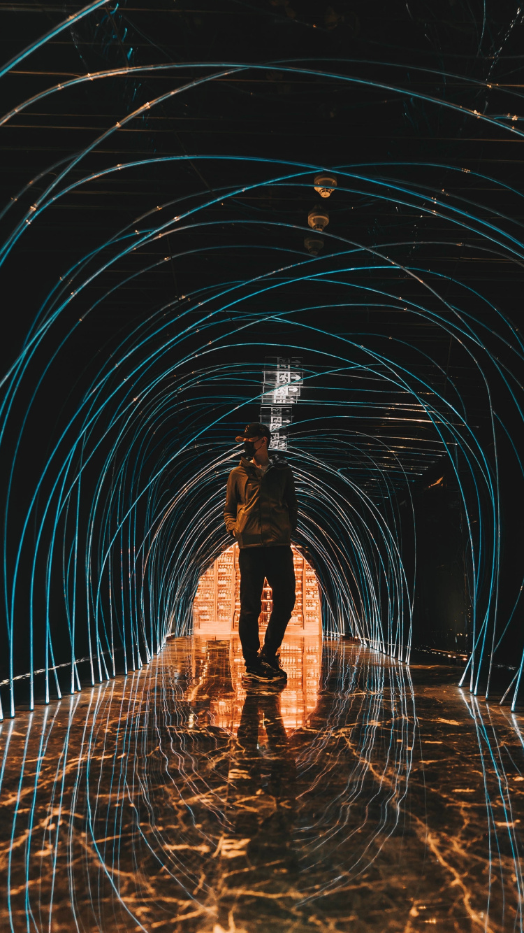 Mann in Schwarzer Jacke Steht im Tunnel. Wallpaper in 750x1334 Resolution