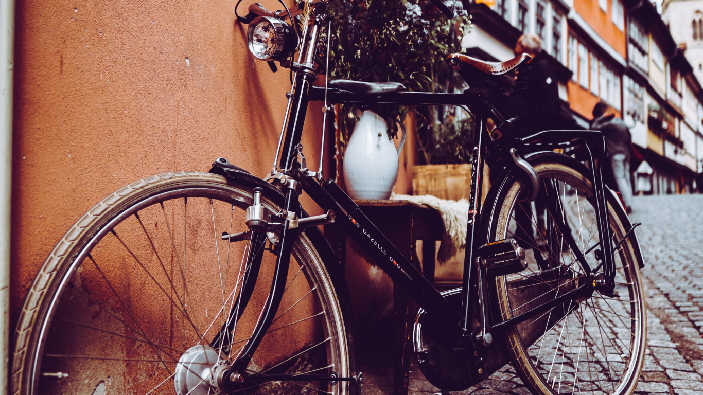 Black City Bike Parked Beside Brown Concrete Wall. Wallpaper in 1366x768 Resolution
