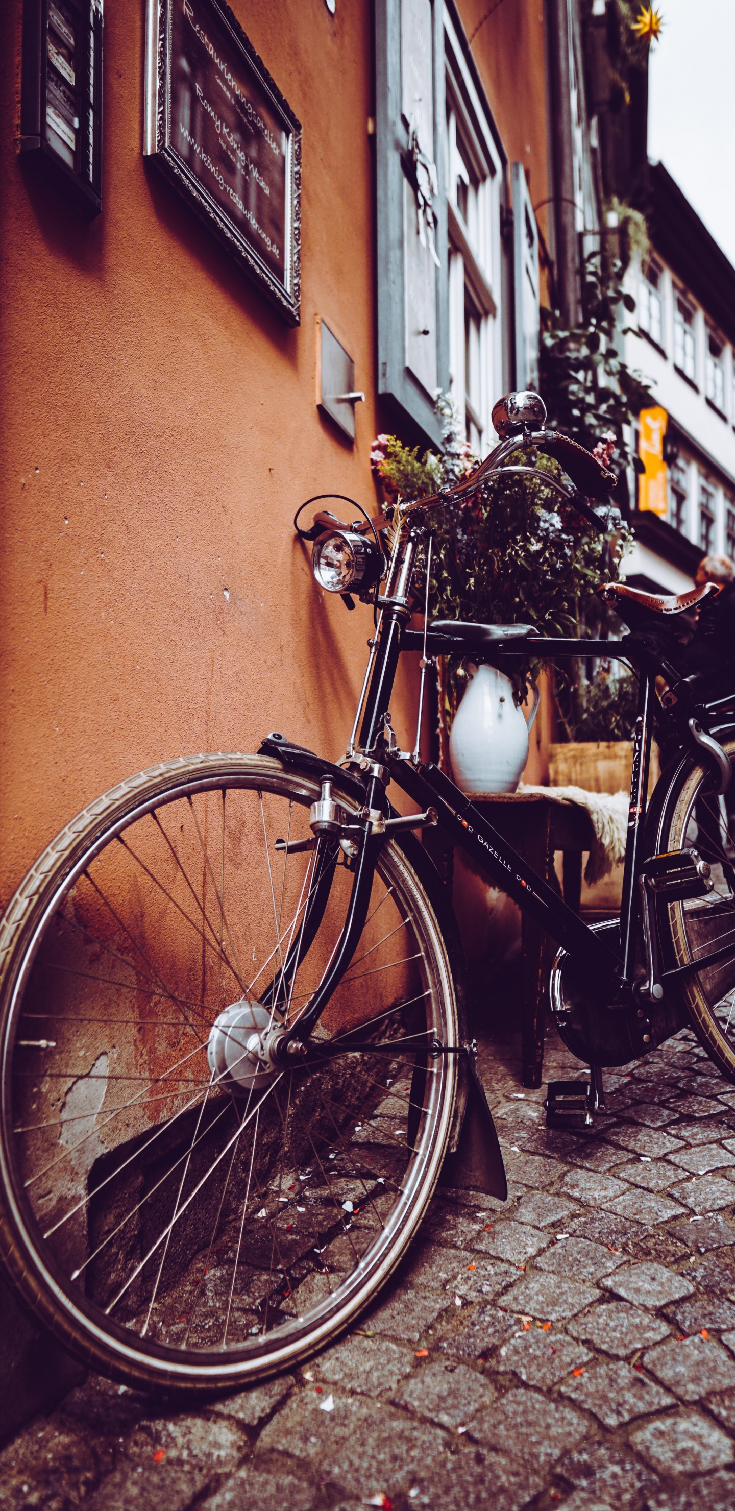 Black City Bike Parked Beside Brown Concrete Wall. Wallpaper in 1440x2960 Resolution