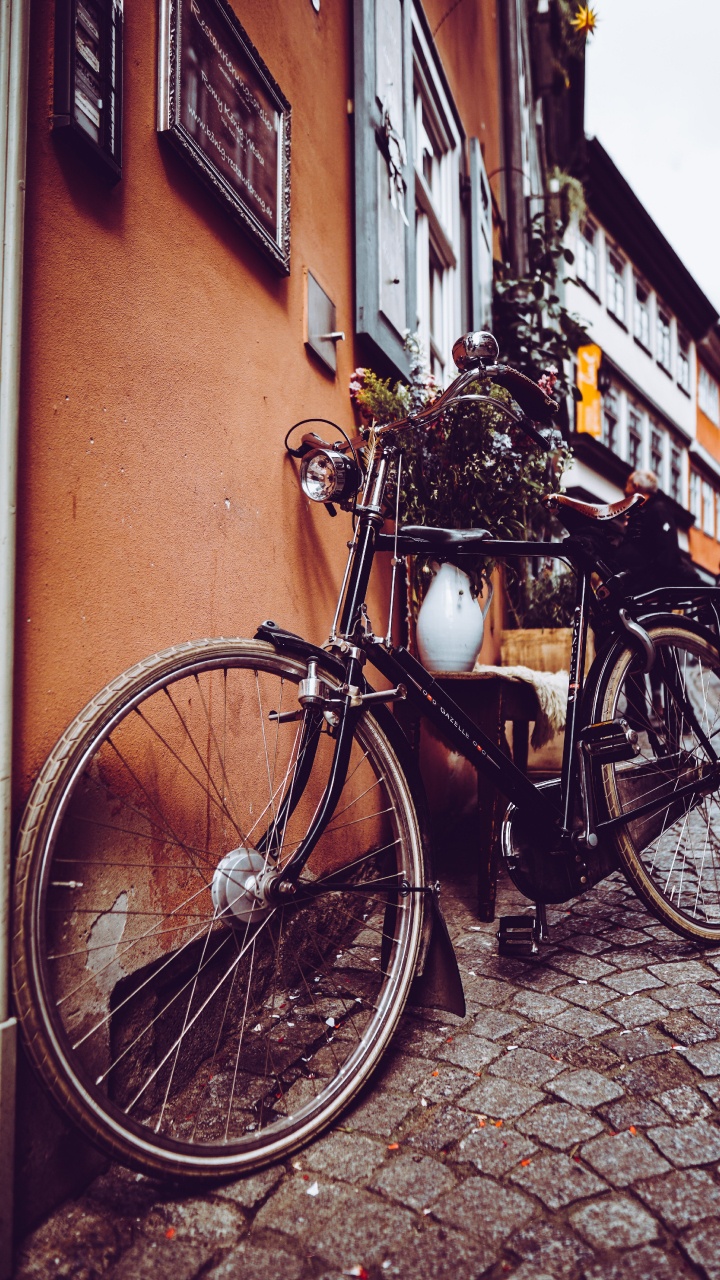 Black City Bike Parked Beside Brown Concrete Wall. Wallpaper in 720x1280 Resolution