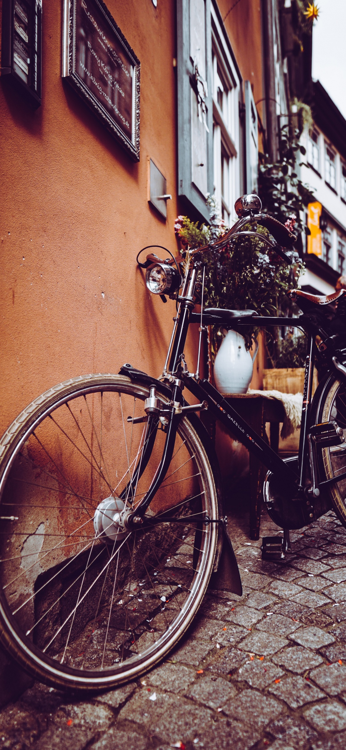 Schwarzes Citybike Neben Brauner Betonwand Geparkt. Wallpaper in 1125x2436 Resolution