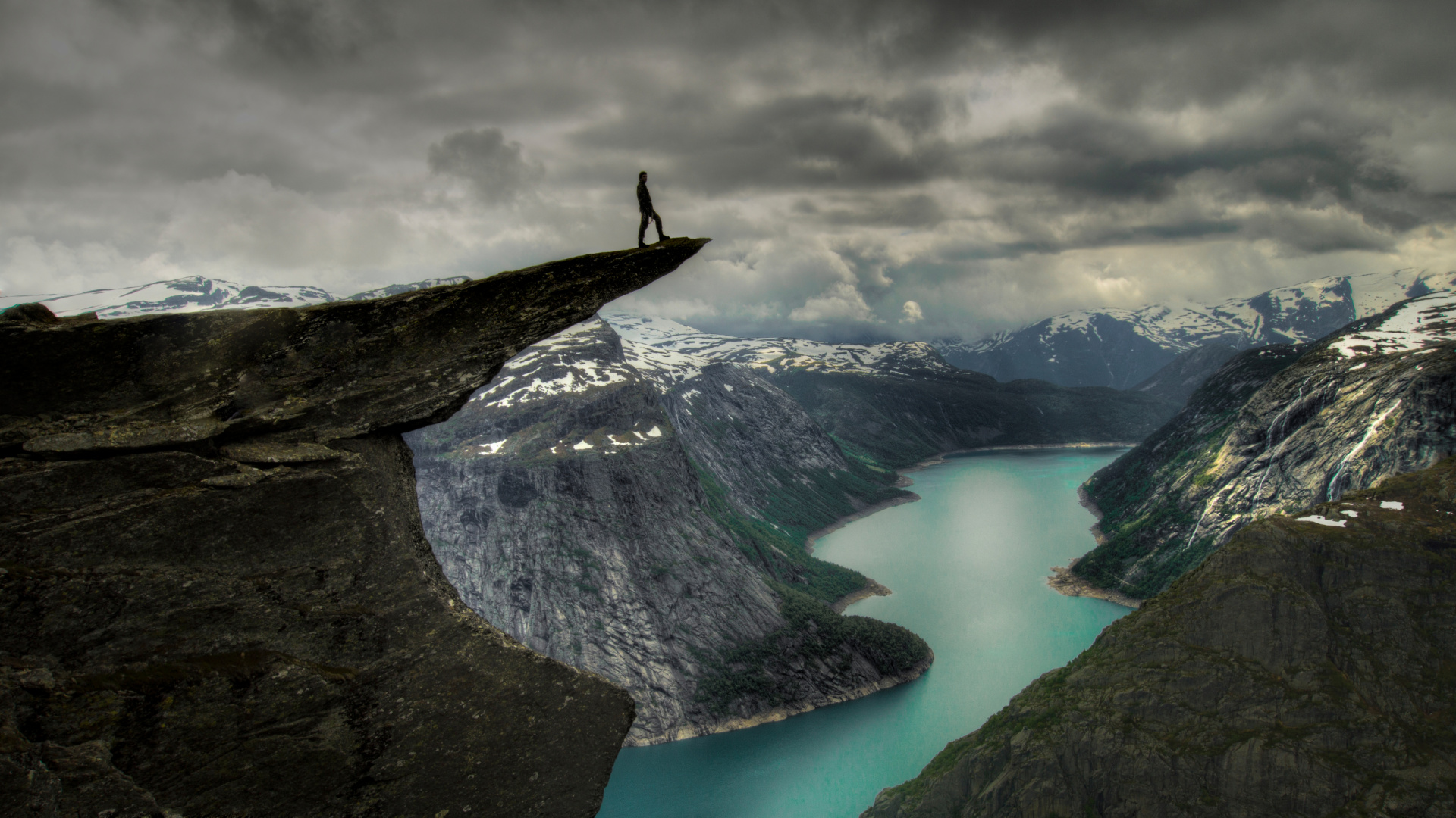 Person Standing on Rock Formation Near Lake Under Cloudy Sky During Daytime. Wallpaper in 1920x1080 Resolution