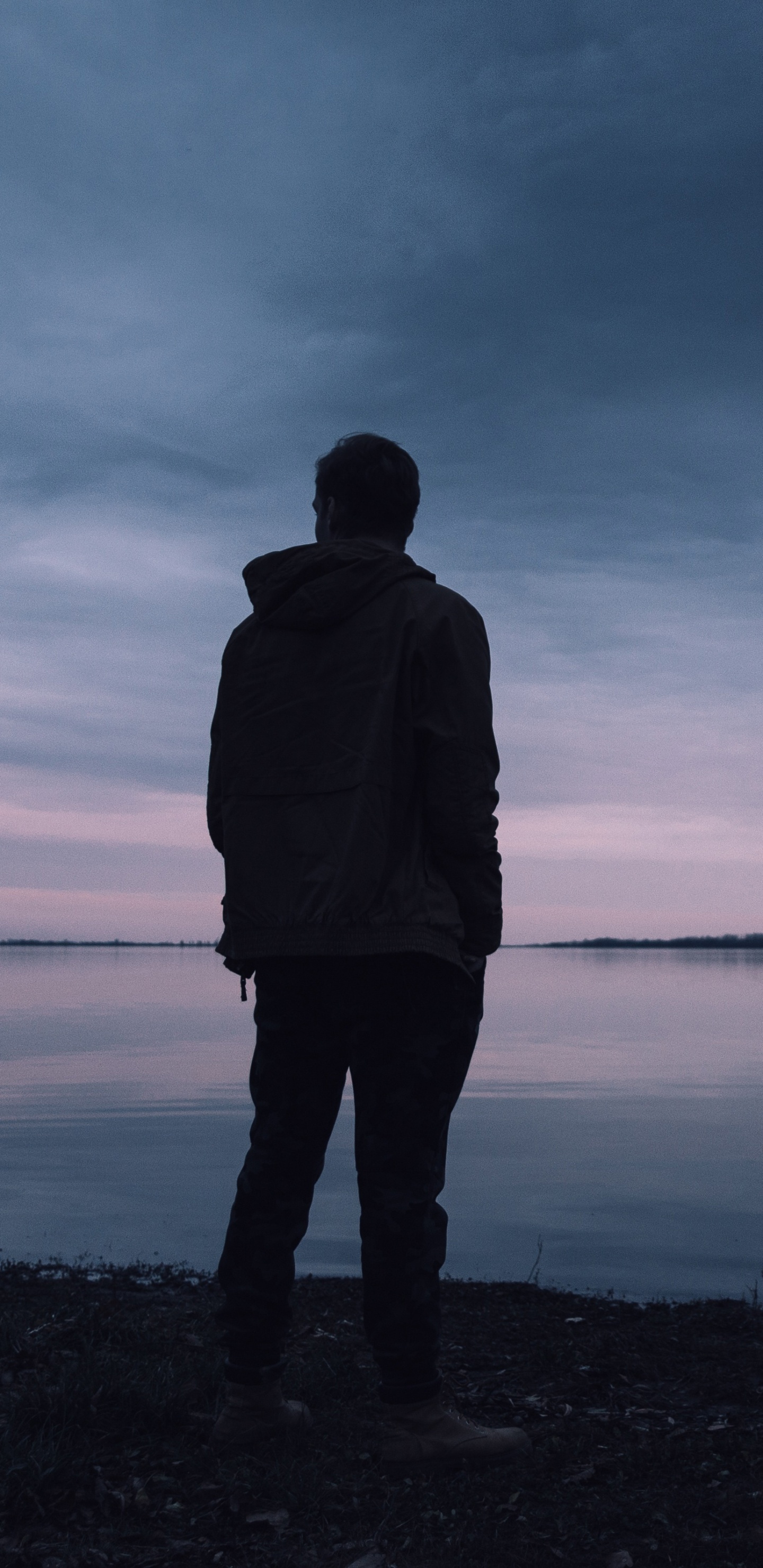 Man in Black Jacket Standing Near Body of Water During Daytime. Wallpaper in 1440x2960 Resolution