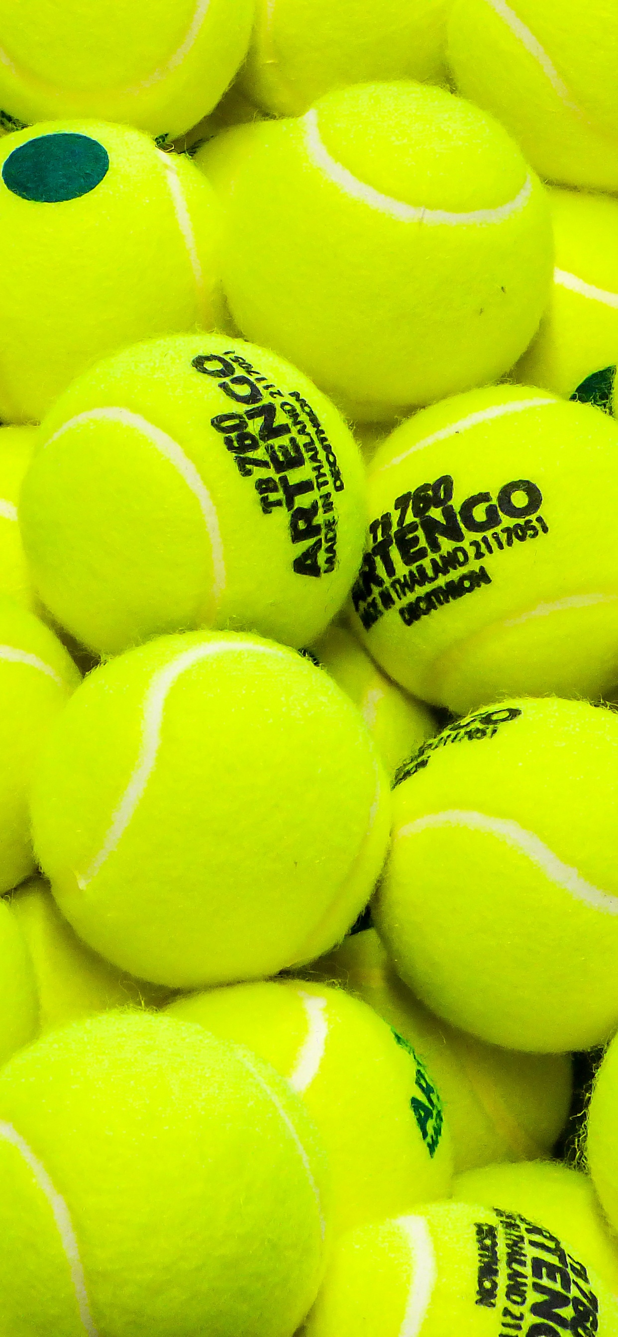 Grüner Tennisball Auf Schwarzem Textil. Wallpaper in 1242x2688 Resolution