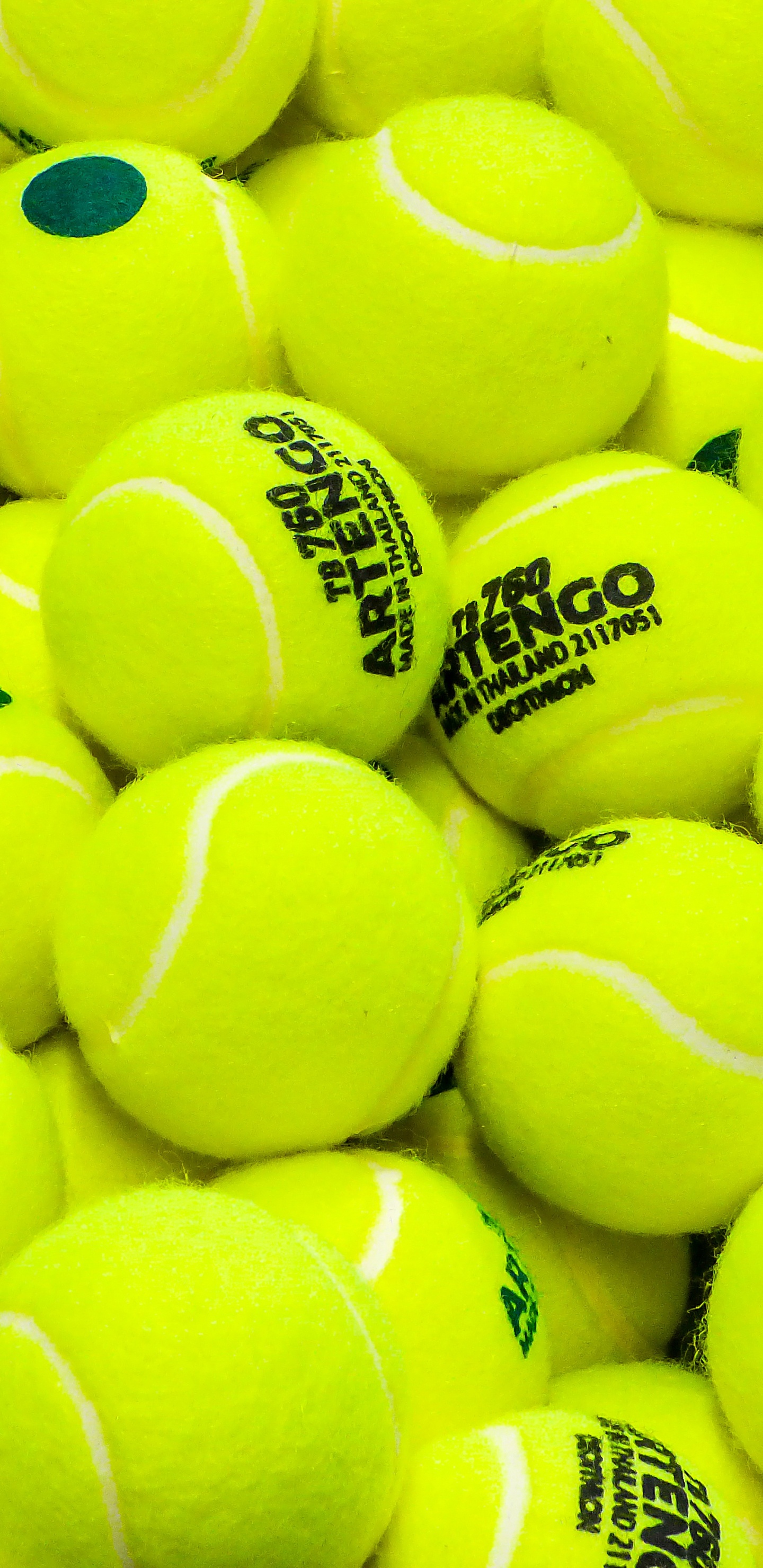 Grüner Tennisball Auf Schwarzem Textil. Wallpaper in 1440x2960 Resolution