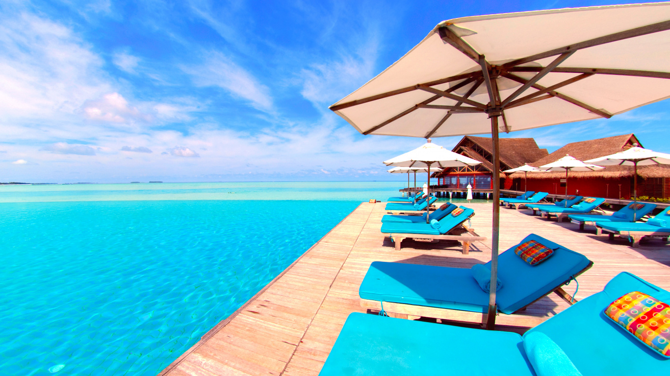 White and Brown Wooden Beach Lounge Chairs on Blue Sea Under Blue Sky During Daytime. Wallpaper in 1366x768 Resolution