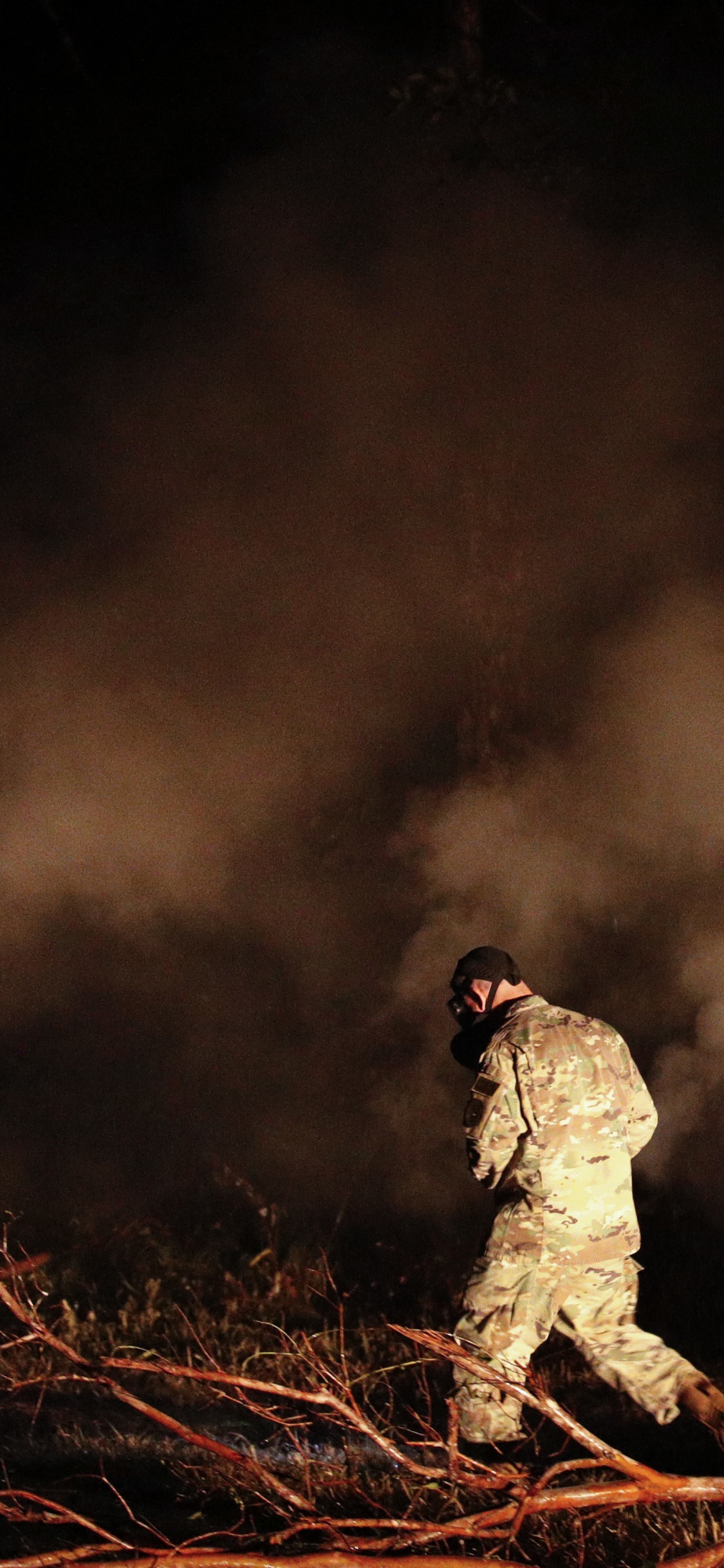 Man in Black Jacket and Pants Sitting on Brown Rock. Wallpaper in 1125x2436 Resolution