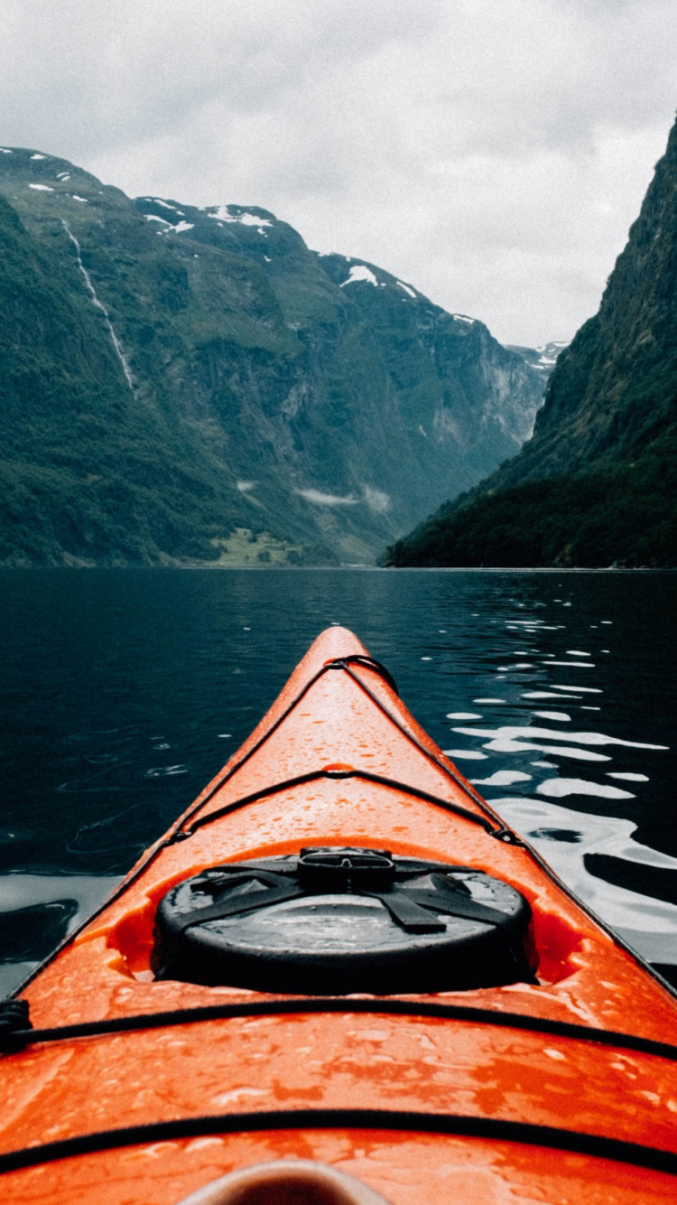 Orange Kayak on Lake Near Mountain Range. Wallpaper in 750x1334 Resolution