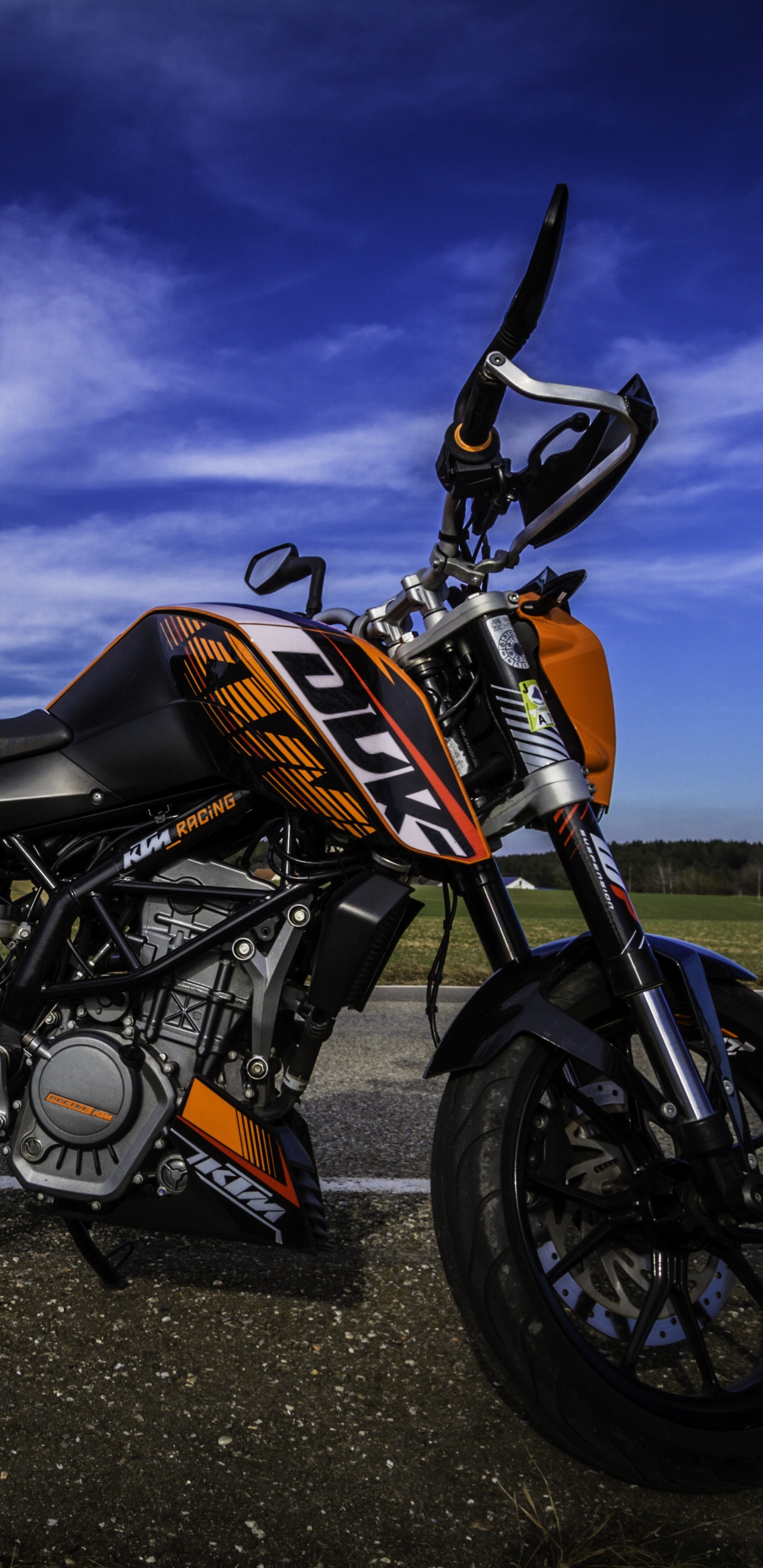 Orange and Black Motorcycle on Black Asphalt Road Under Gray Cloudy Sky. Wallpaper in 1440x2960 Resolution