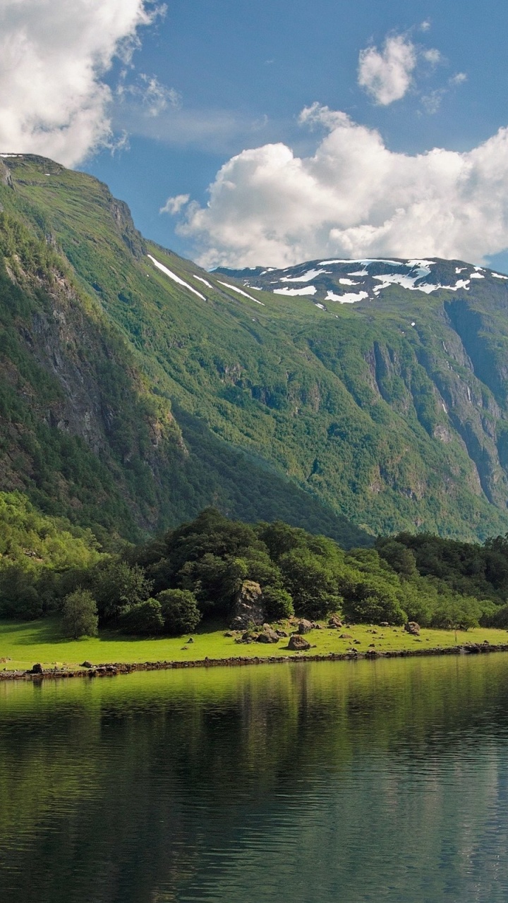 Montagnes Vertes à Côté du Lac Sous Ciel Bleu Pendant la Journée. Wallpaper in 720x1280 Resolution
