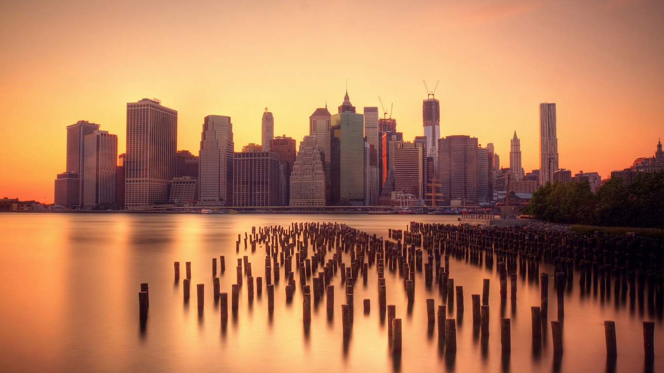 City Skyline Across Body of Water During Sunset. Wallpaper in 1366x768 Resolution