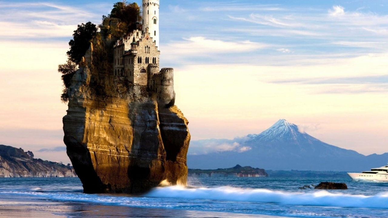 Edificio de Hormigón Gris en la Parte Superior de la Formación de Roca Marrón Cerca Del Cuerpo de Agua Durante el Día. Wallpaper in 1280x720 Resolution